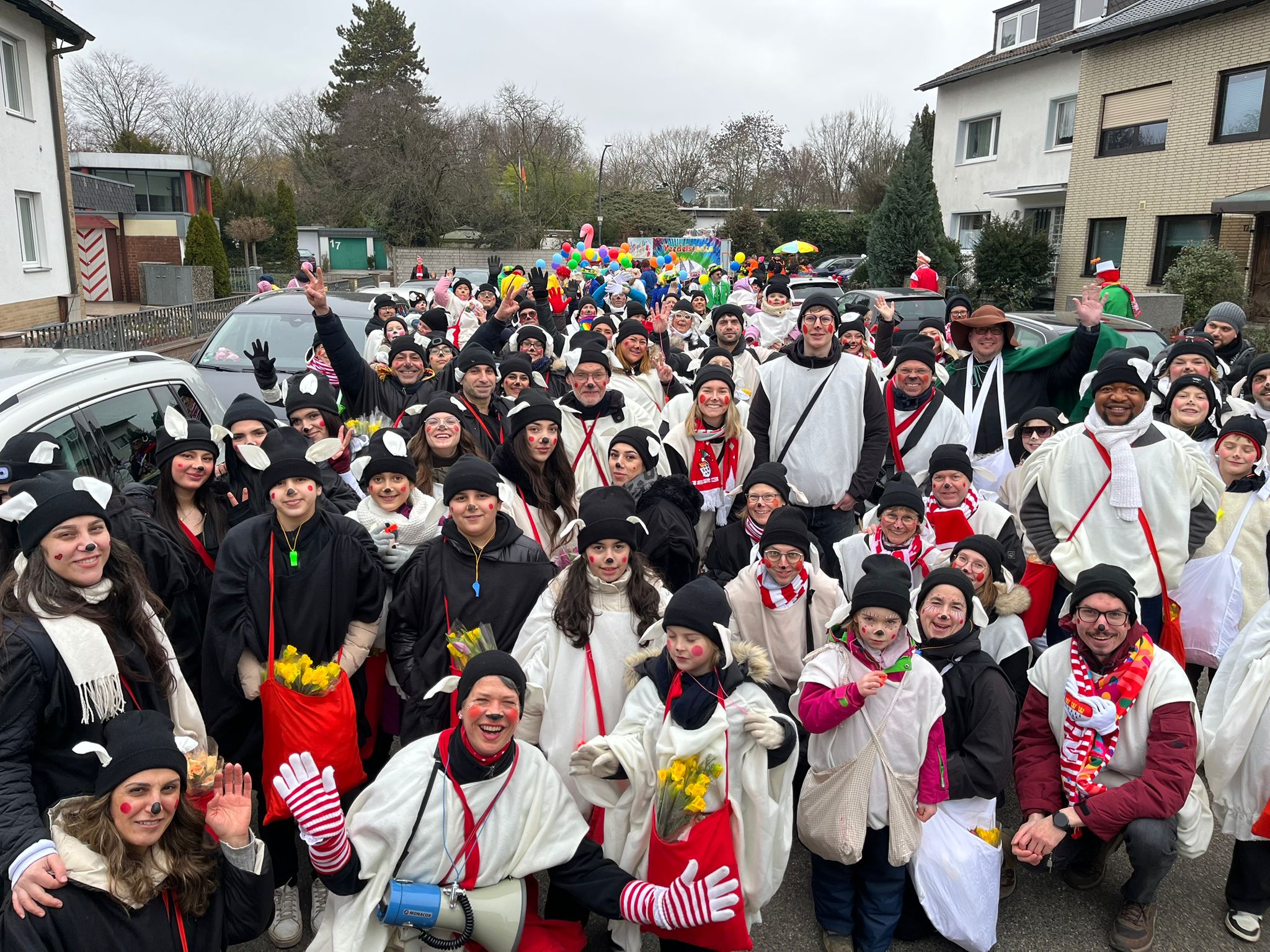 Gruppenbild der Karnevalsgruppe von St. Gereon Merheim als Schäfchen von St. Gereon verkleidet. Etwa 100 Personen allen Altern mit vielen neuen Nachbarn